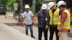 Pekerja melakukan perbaikan jalan di Kabupaten Jepara menggunakan alat berat