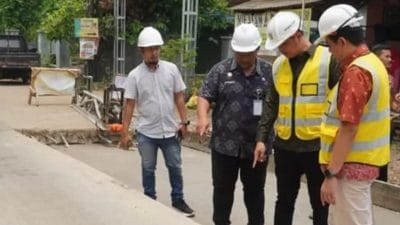 Pekerja melakukan perbaikan jalan di Kabupaten Jepara menggunakan alat berat