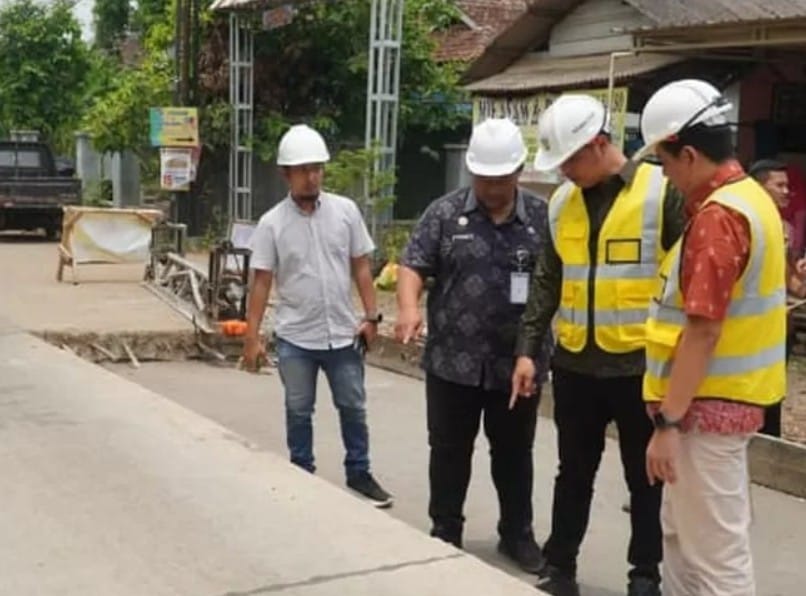 Pekerja melakukan perbaikan jalan di Kabupaten Jepara menggunakan alat berat