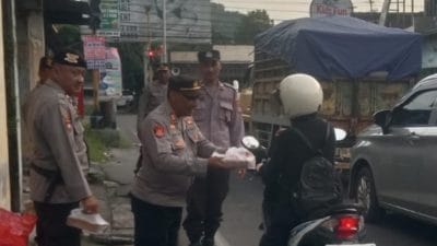 Personel Polsek Piyungan membagikan takjil gratis kepada pengendara di Simpang Tiga Piyungan Bantul saat Ramadhan 2026